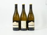 trois bouteilles de vin posées l'une à côté de l'autre sur une table