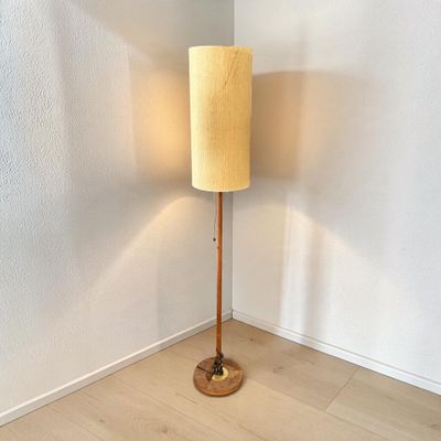 une lampe posée sur un pied en bois dans une pièce