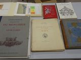 several books are on a table with a chair in the background