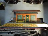 a model of a train station with a man standing on the platform