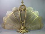 a gold fan with intricate designs on it on a table