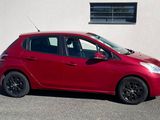 une petite voiture rouge garée devant un immeuble
