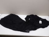 a black shirt on a white table with a tag on it