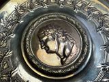 a silver plate with a picture of a horse on it
