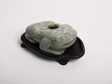 two donuts sitting on a black plate on a white surface