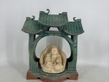une petite statue représentant une personne assise dans un petit sanctuaire