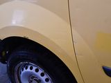 a close up of a yellow van parked in a parking lot