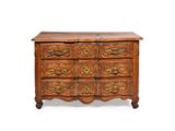 une commode ancienne dont les tiroirs sont ornés de sculptures élaborées