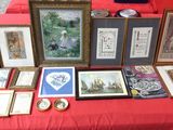 many framed pictures on a red table with a red table cloth
