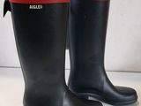 une paire de bottes de pluie noires avec des bordures rouges sur un fond blanc