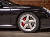 a black sports car parked in front of a brick wall