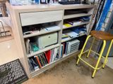un tabouret jaune posé devant une bibliothèque remplie de livres