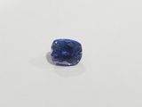 a blue sapphire stone on a white surface