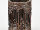un vase en bois orné de sculptures sur un fond blanc