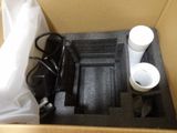 a box that has a cup and a charger inside of it