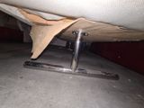 underside view of a bed with a mattress on a metal stand