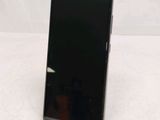 the back of a black cell phone sitting on top of a white table