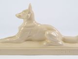 statue of a dog laying down on a base on a white background