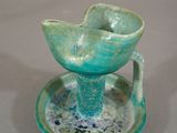 une tasse et une soucoupe bleues et vertes posées sur une assiette