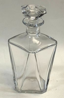 a clear glass bottle with a bird on top