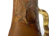 a brown vase with a handle on a white surface