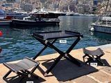 a table and two chairs on the dock next to the water