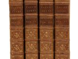 quatre vieux livres posés l'un sur l'autre sur une surface blanche