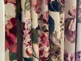 many different floral curtains hanging on the wall