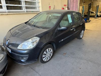 La voiture noire est garée dans le garage, à côté de la voiture argentée.
