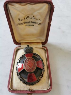 une médaille rouge et noire dans un écrin rouge