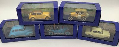 six petites voitures miniatures se trouvent dans une boîte bleue posée sur une surface blanche