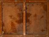 a rusted metal cabinet with two doors and a window