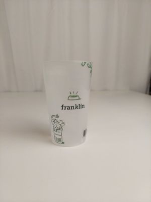 un verre orné d'un dessin, posé sur une table