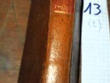 un vieux livre posé sur une table, avec un bout de papier à côté