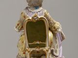 a figurine of a woman sitting on a chair