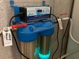 un filtre à eau fixé au mur à côté d'un chauffe-eau