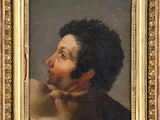 portrait d'un homme avec un chat, à côté d'un tableau représentant un chien