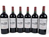 six bottles of red wine are lined up on a white surface