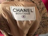 a person holding a chanel coat with a label on it