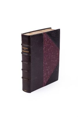 un vieux livre à la couverture violette posé sur une surface blanche