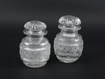 pair of clear glass salt and pepper shakers on a black background
