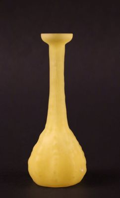 un vase jaune posé sur une table noire