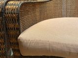 pair of wicker chairs in a living room with a mirror on the wall