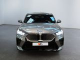 the front of a silver bmw suv parked in a showroom