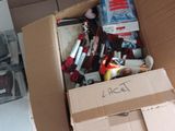 une boîte en carton remplie d'objets hétéroclites sur le sol