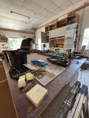 un établi au milieu d'une pièce, sur lequel sont posés de nombreux outils