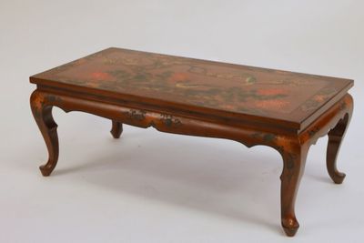 une petite table en bois ornée d'un motif floral