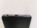 the back of a black samsung phone sitting on top of a table