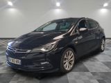 une voiture noire est garée dans une grande pièce au sol en damier