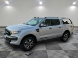 Un Ford Ranger argenté est garé dans une pièce dont le sol est en damier.